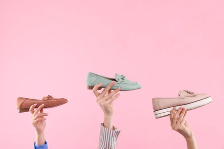 Women with different stylish shoes on pink background, closeup. Space for text