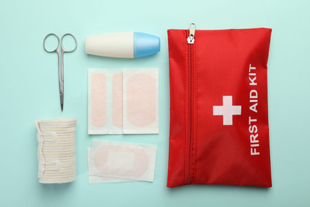 First aid kit. Different medical supplies on light blue background, flat lay