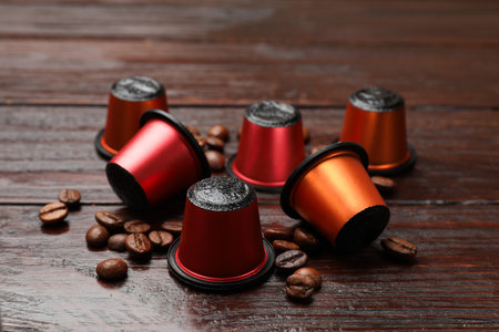 Coffee capsules and beans on wooden table, closeupの写真素材