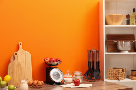 Kitchen scale, products and cooking utensils on wooden table. Space for textの写真素材