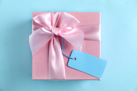 Gift box with blank tag on light blue background, top viewの写真素材