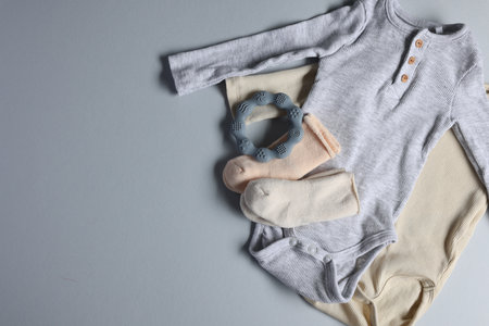 Baby clothes and teether on light grey background, flat lay. Space for textの写真素材