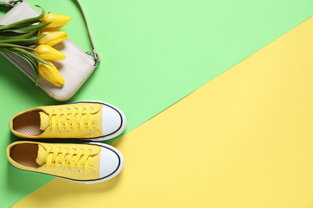 Stylish shoes, bag and yellow tulips on color background, flat lay. Space for textの写真素材