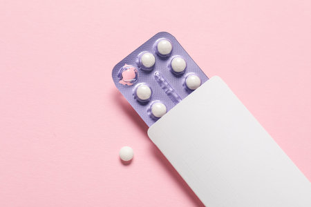 Blister of oral contraceptive pills on pink background, top view. Space for textの写真素材