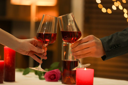 Couple clinking glasses of wine in restaurant, closeup. Romantic dinnerの写真素材