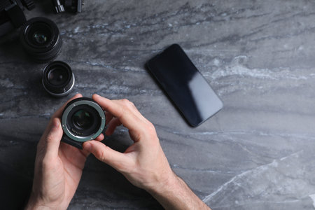 Photographer with camera lens at gray marble table, top view. Space for textの写真素材