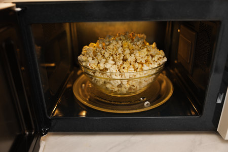 Bowl of tasty popcorn in microwave oven, closeupの写真素材