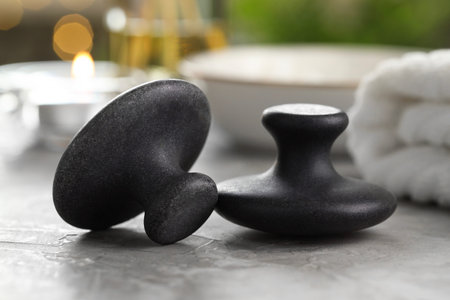 Massage stones on grey background, closeup. Spa treatment