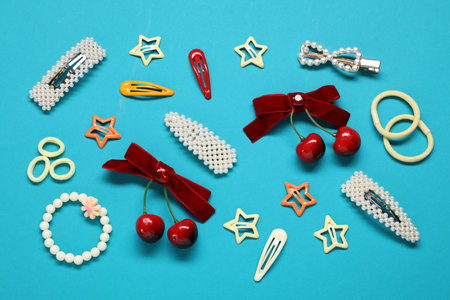 Different hair accessories on light blue background, flat lay