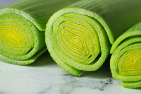 Whole fresh leeks on white marble table, closeupの写真素材