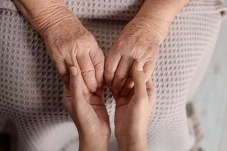 Caregiver supporting senior woman on light background, top view. Elderly careの写真素材