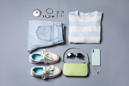 Fashionable outfit. Layout with women's clothes and accessories on grey background
