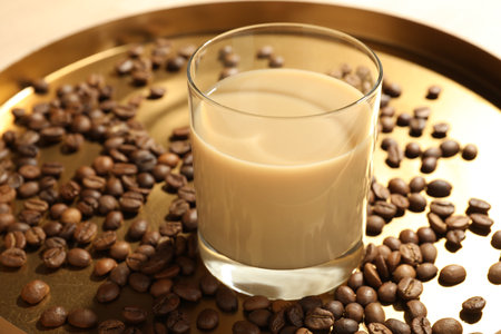 Coffee cream liqueur in glass and beans on tray, closeupの写真素材