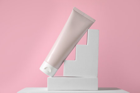 Tube of sun protection product on podium against pink backgroundの写真素材