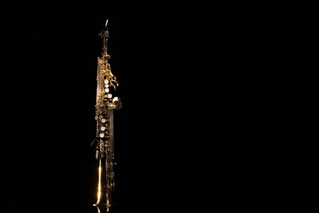 Jazz. One saxophone on mirror surface against black background, space for textの写真素材