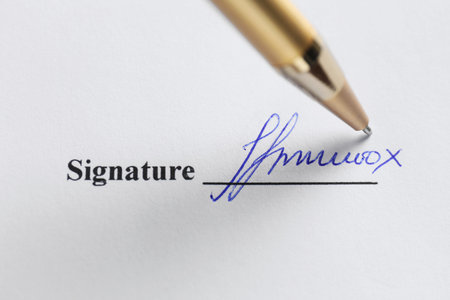 Pen leaving signature on contract, top view