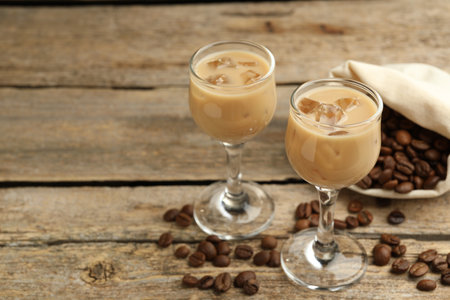Coffee cream liqueur in glasses and beans on wooden table, closeup. Space for textの写真素材