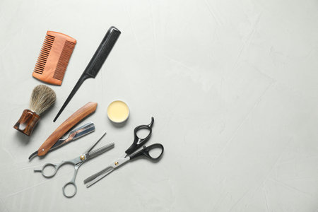 Many different barber's tools on light gray table, flat lay. Space for textの写真素材