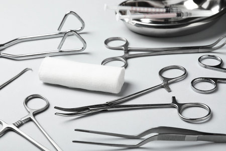 Different surgical instruments on light grey background, closeup