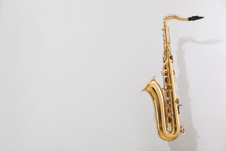 Golden saxophone on light grey background. Space for textの写真素材