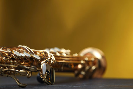Jazz. One beautiful saxophone on black table against color background, closeupの写真素材