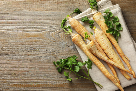 Raw parsley roots with leaves on wooden table, top view. Space for textの写真素材