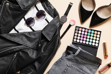 Stylish women's outfit. Clothes, accessories and makeup products on beige background, flat layの写真素材