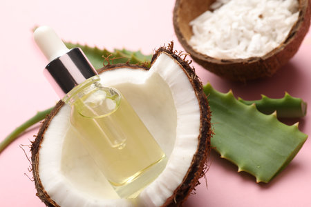 Hair treatment. Cosmetic product, coconut, butter and aloe leaves on pink background, closeupの写真素材