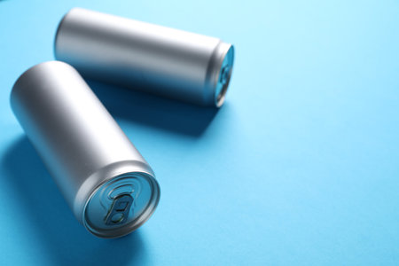 Two tin cans on light blue background, closeup. Space for textの写真素材