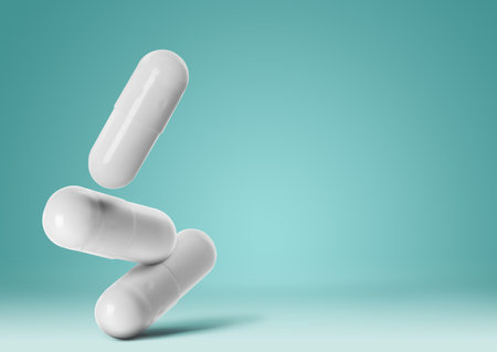 Medical pills falling on turquoise background, space for textの写真素材