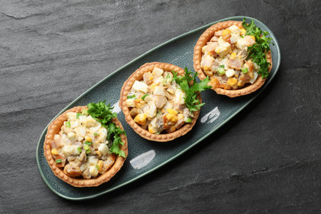 Tartlets with delicious filling on black table, top viewの写真素材
