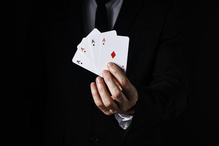 Illusionist with playing cards on black background, closeupの写真素材