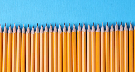 Many pencils on light blue background, top view. Space for text