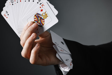 Illusionist with playing cards on grey background, closeupの写真素材