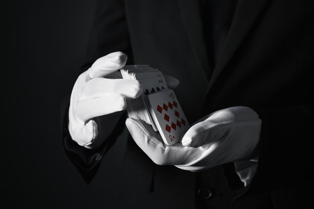 Illusionist shuffling playing cards on black background, closeupの写真素材