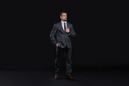 Confident man in classic suit on black backgroundの写真素材