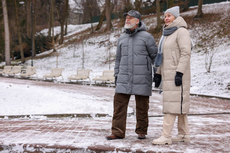 Happy senior couple walking in winter park. Space for textの写真素材