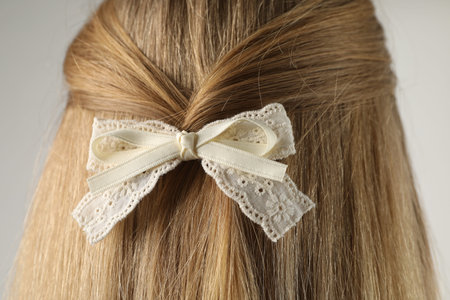 Woman with beautiful hair bow on light grey background, back viewの写真素材