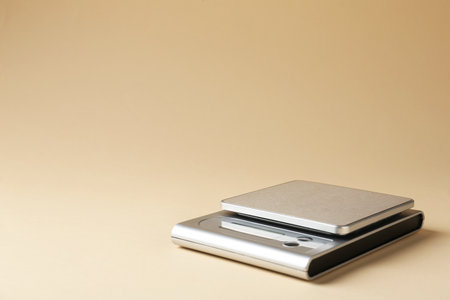 Modern electronic kitchen scale on beige background. Space for textの写真素材