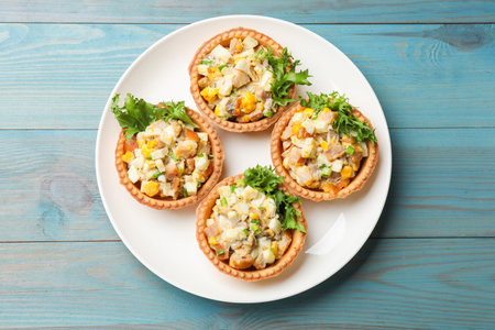 Tartlets with delicious filling on blue wooden table, top viewの写真素材