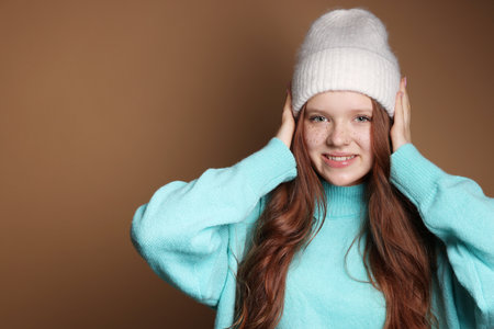 Teenage girl with freckles in hat on brown backgroundの写真素材