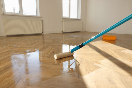Polishing parquet with roller and varnish indoors, closeupの写真素材