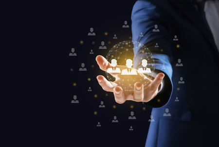 Targeting, recruitment, customer acquisition. Businessman holding virtual scheme with human icons against black background, closeupの写真素材