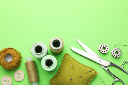 Different sewing supplies on green background, flat lay. Space for textの写真素材