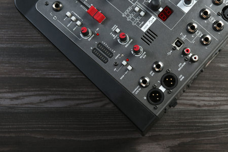 Professional mixing console on wooden table, top view. Space for text