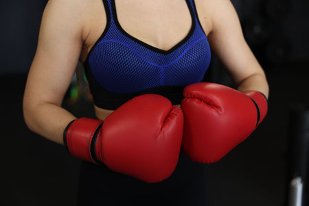 Woman in boxing gloves on black background, closeupの写真素材