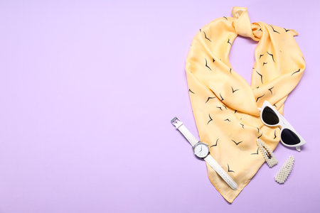 Beautiful scarf and stylish accessories on lilac background, flat lay. Space for textの写真素材