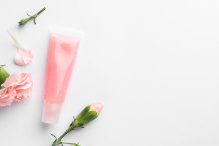 Lip balm and eustoma flowers on white background, flat lay. Space for textの写真素材