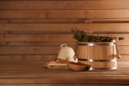 Bucket, ladle and on wooden bench in sauna. Space for textの写真素材