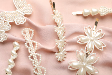 Beautiful hair clips on pink silk fabric, flat layの写真素材